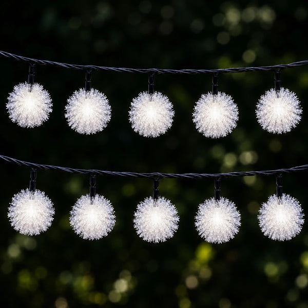 String of white pom-pom lights against a dark background