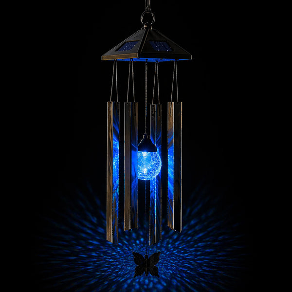Solar powered wind chime with blue light on a black background